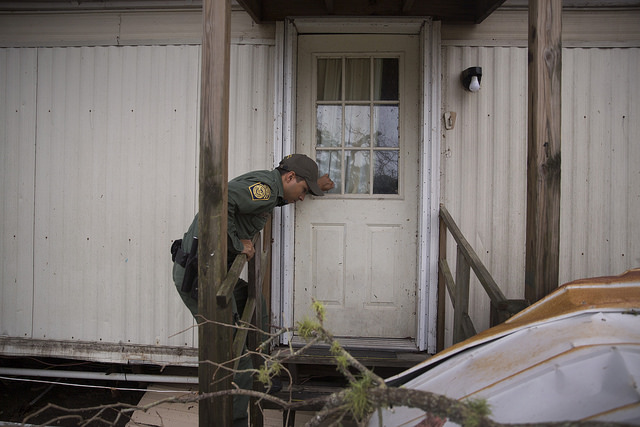 A U.S Border Patrol agent knocks on the door of a mobile home as he and his cohorts conduct search and rescue operations in the wake of Hurricane Harvey near Lockport, Texas. (August 27, 2017) U.S. Customs and Border Protection Photo: Glenn Fawcett