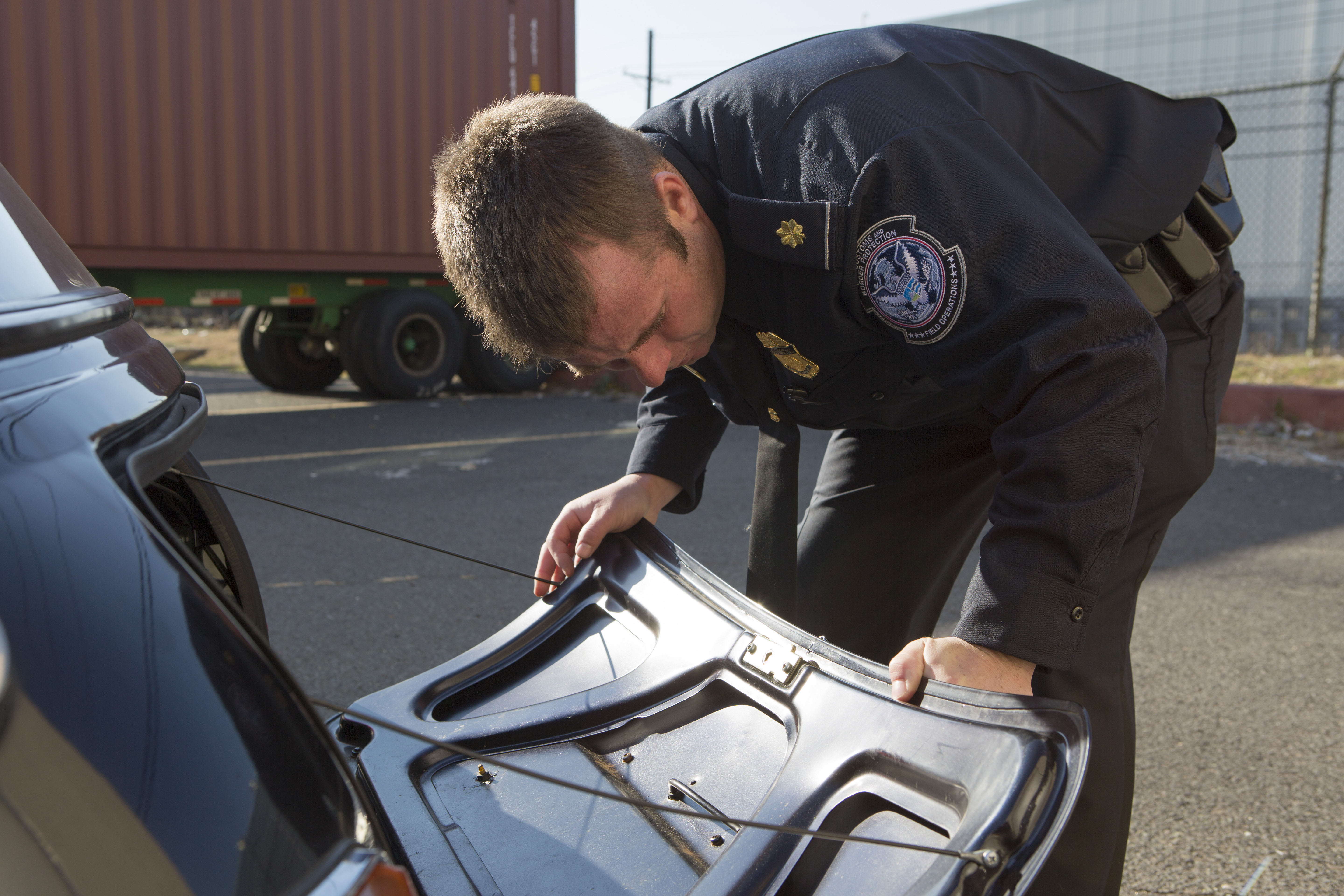 A Customs and Border Protection Officer inspects a Mini Cooper that arrived to Port Elizabeth NJ that had numerous violations associated with it related to importation. This vehicle will be destroyed as a result. Photo Credit: James Tourtellotte