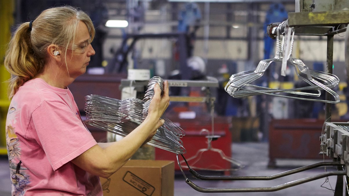 Heather Smith, a hanger machine operator, inspects the shape and consistency of newly manufactured hangers.
