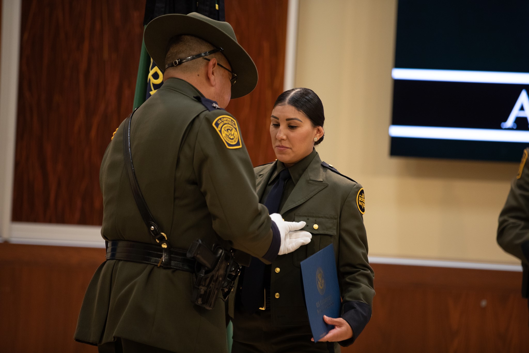 A Border Patrol agent receives her badge during graduation from the Border Patrol Academy.