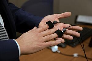 Hands holding polygraph technology.