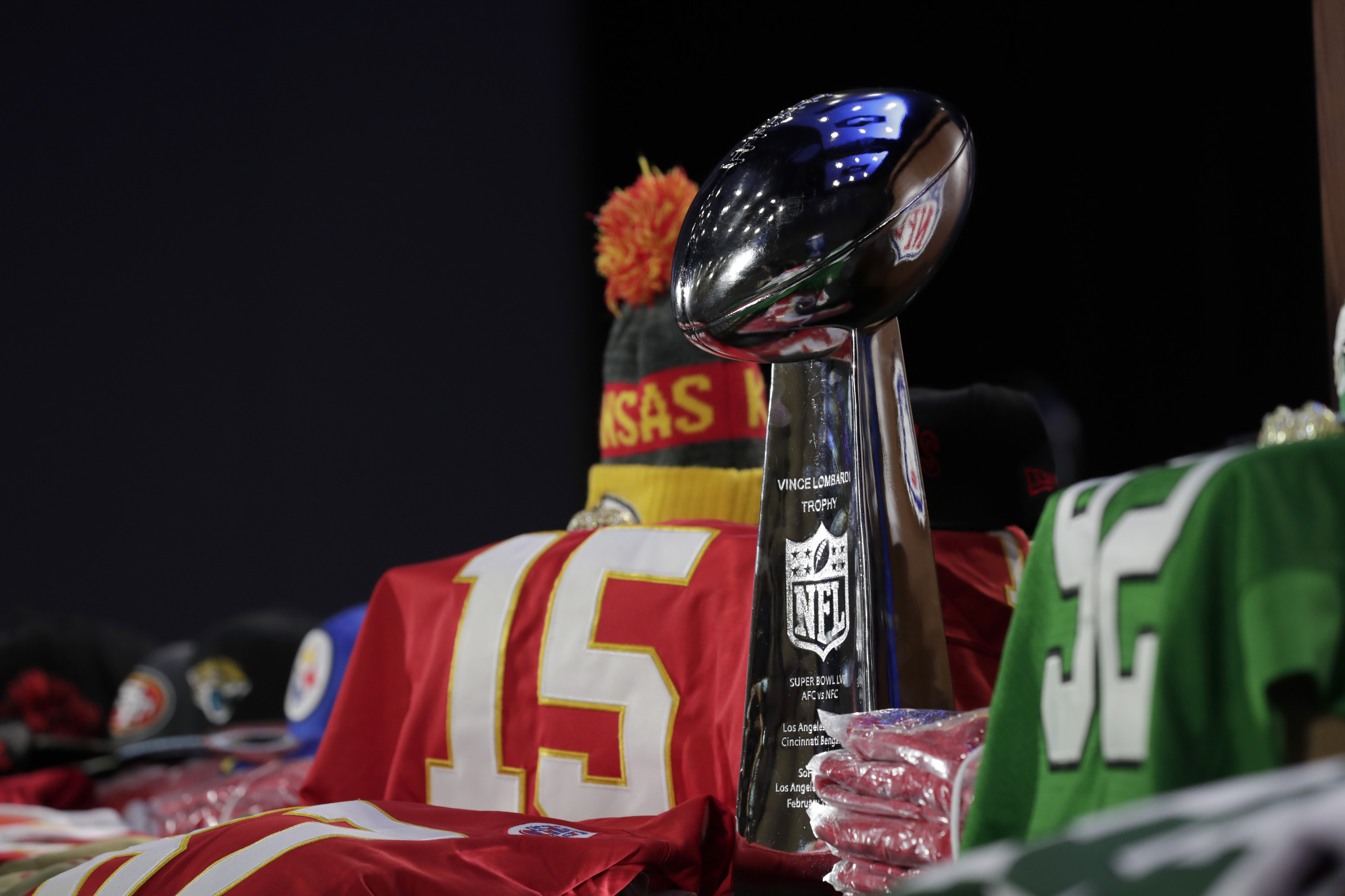 A fake Vince Lombardi Trophy stands above a table of counterfeit souvenirs.