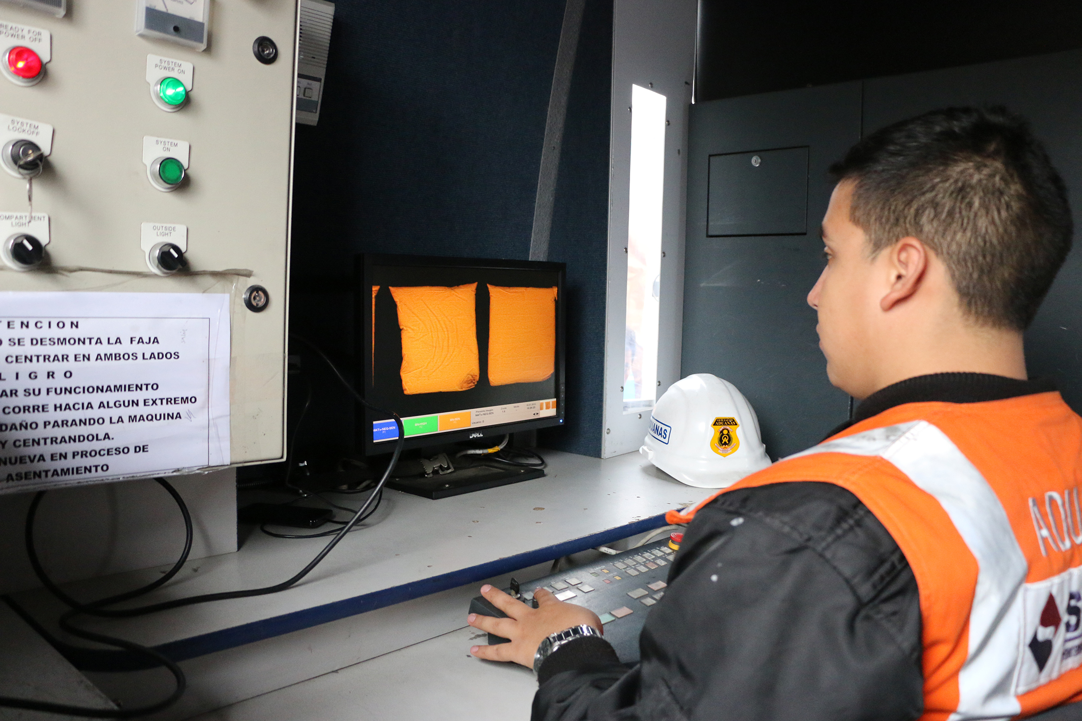 Photo of a Peruvian Customs officer examining bags of quinoa using an X-ray screening system in Calleo, Peru.