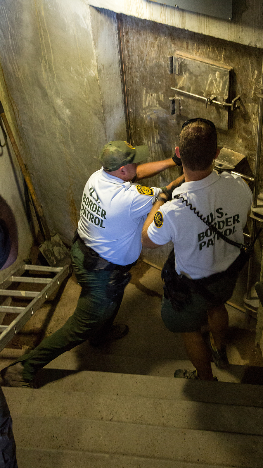 Border Patrol agents open an entrance to an area in the drainage system.