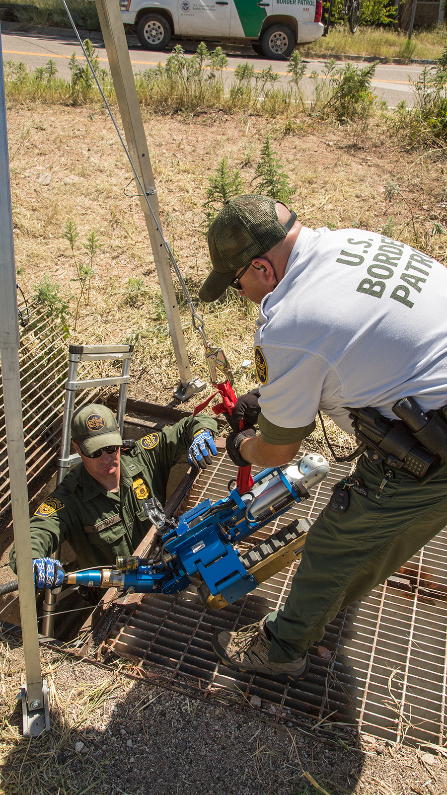 Border Patrol agents remove the robot from the drainage pipe after it completes the task.