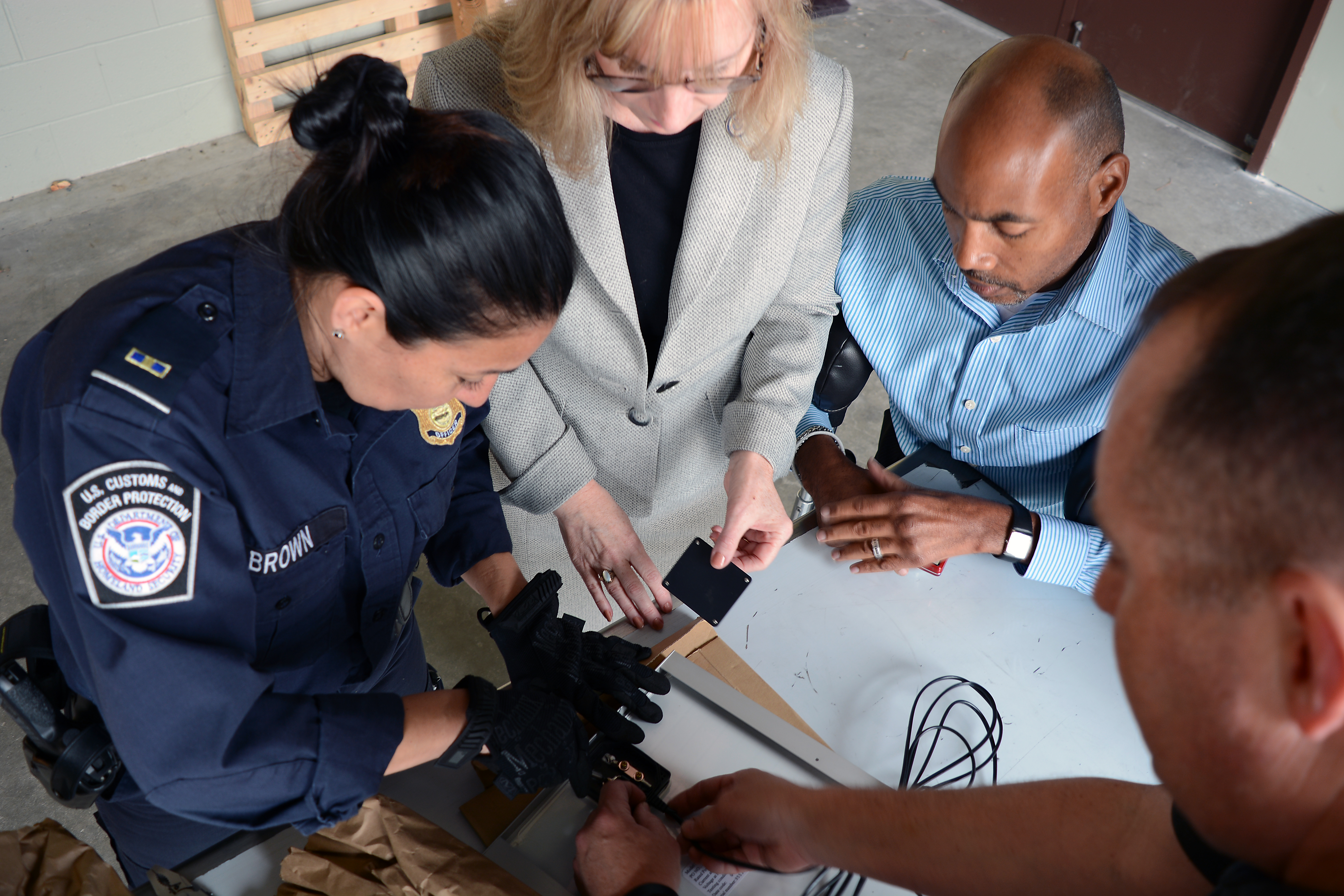 Port of Charlotte team members, l-r, CBP Officer Joyce Brown, Senior Import Specialist Laurie Pazzo, Supervisory Import Specialist Wilbert Jones, and Import Specialist Jeff Sorrells, examine the back of a solar panel to better understand its construction. Photo by Scott Sams