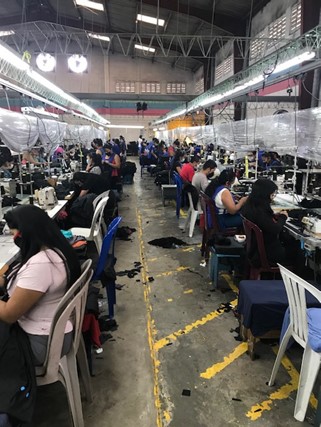 Individuals working in a factory being inspected by CBP.