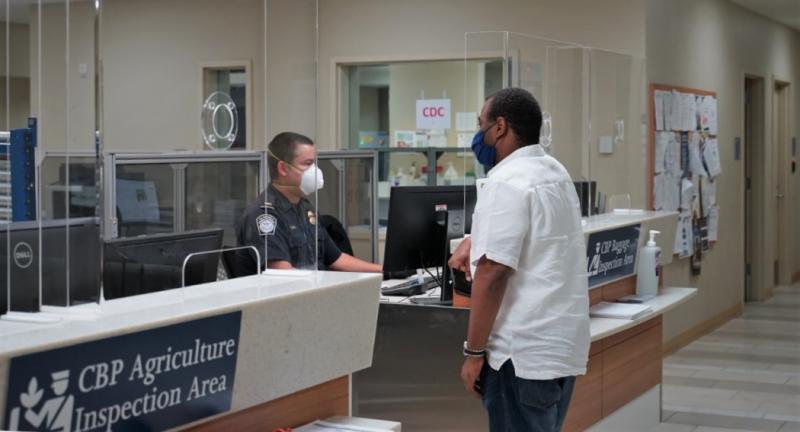A CBP officer talks with a traveler