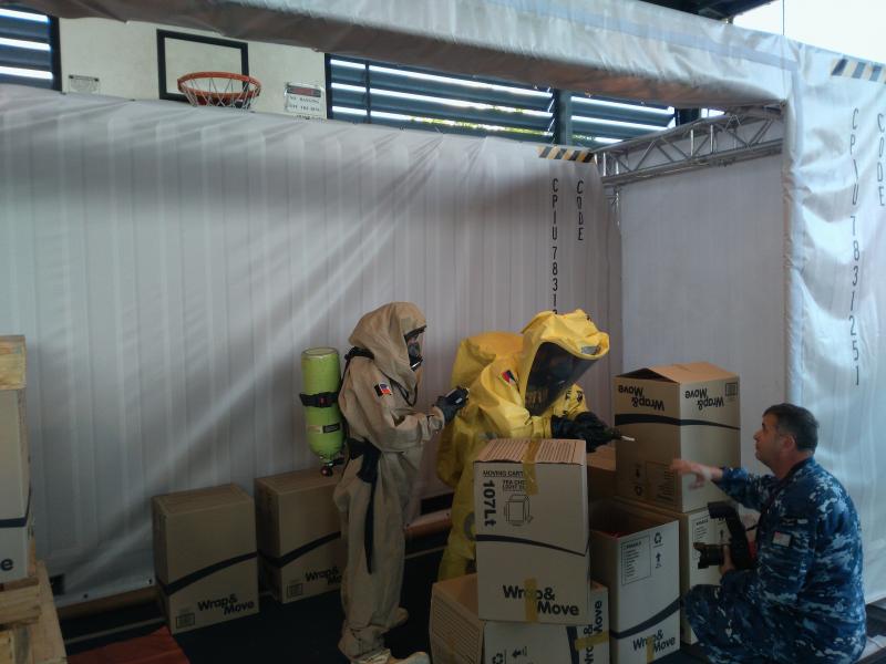 Two individuals in WMD protective clothing conducting an inspection during an exercise