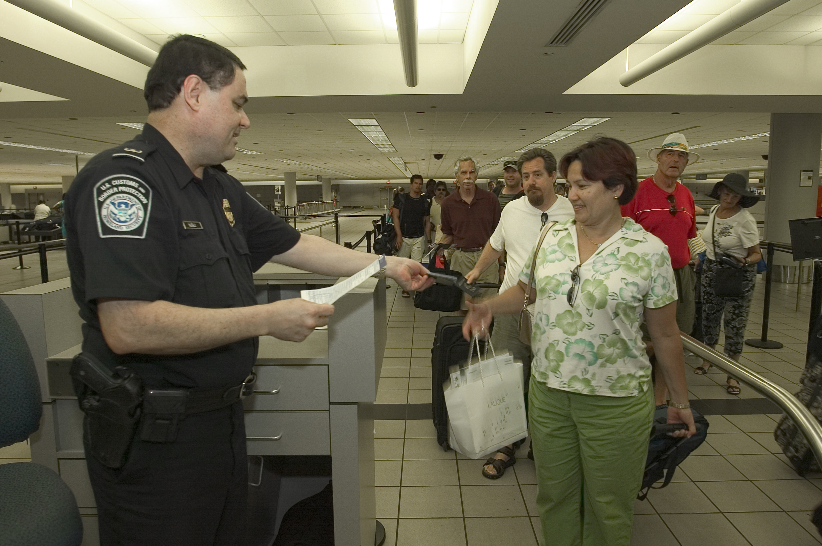 A CBP officer checks a passenger's documentation after arrival into the U.S.