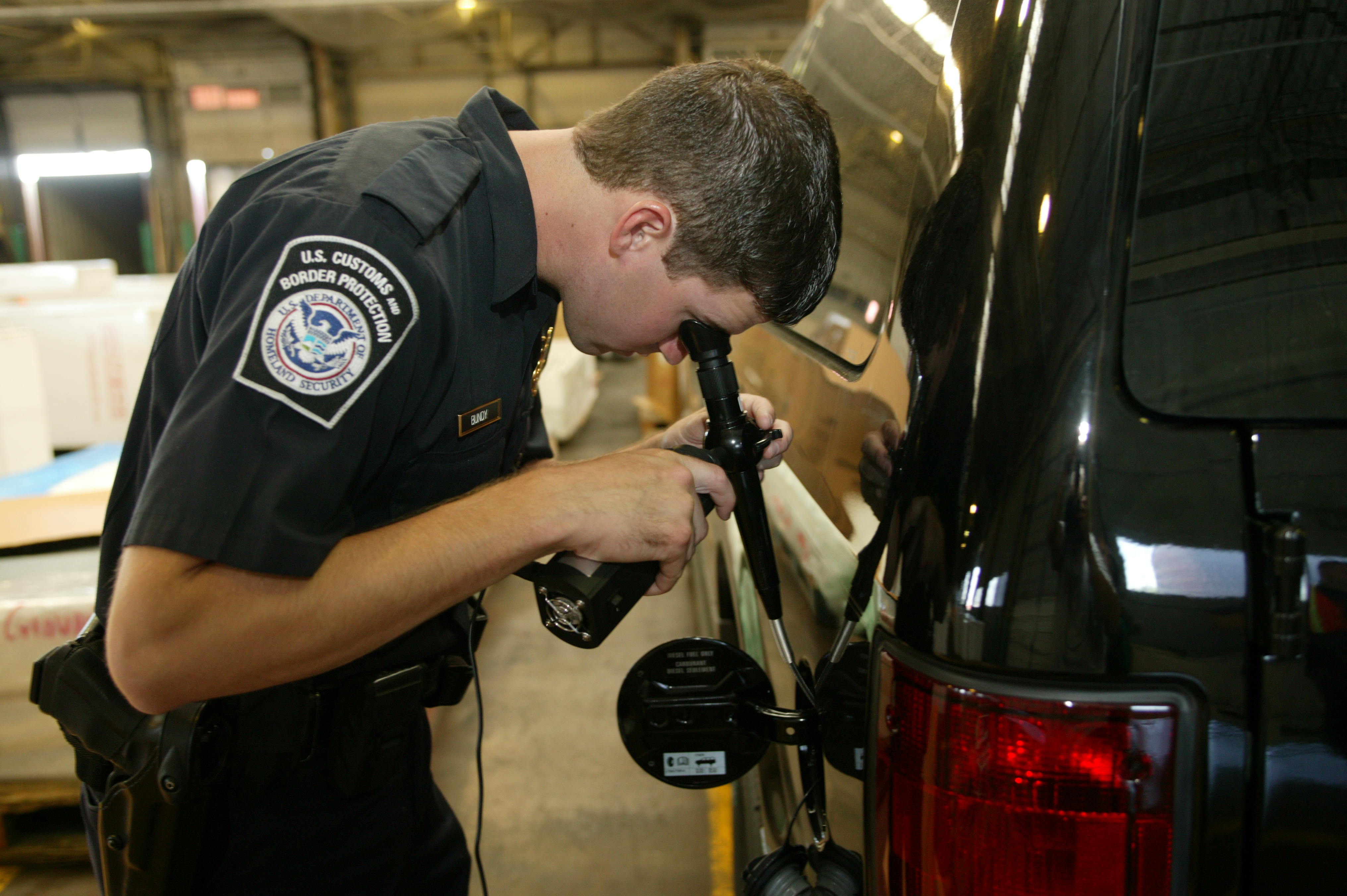 This CBP officer uses a high tech device to "peek" inside a drum for contraband.
