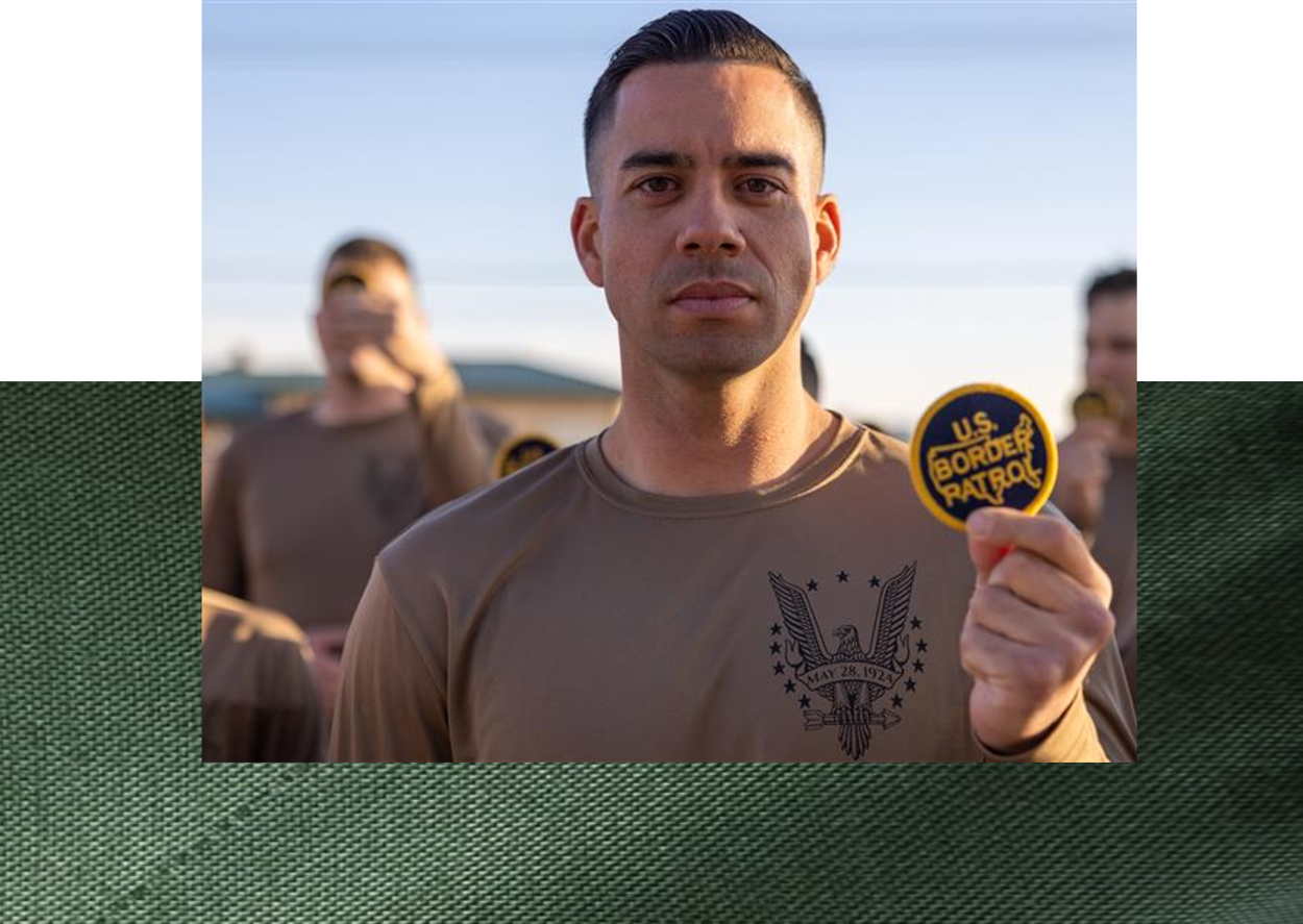 Male Border Patrol Agent at the academy holding the USBP patch
