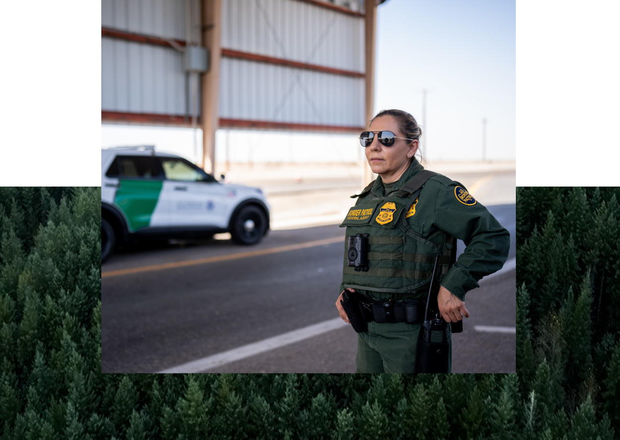 Female Border Patrol Agent standing in front of a government vehicle