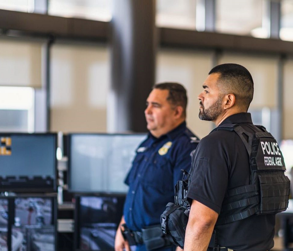 Female CBP Officer using facial recognition technology on a traveler