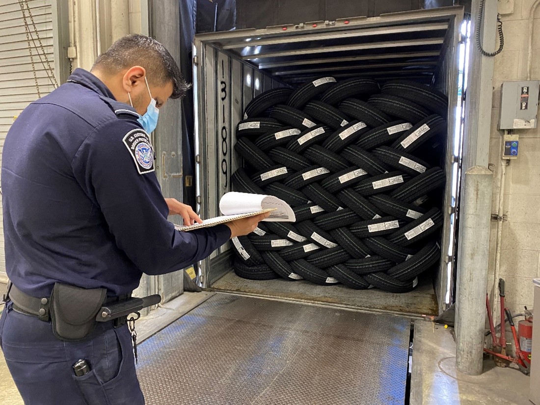 A CBP officer examines a tire manifest.