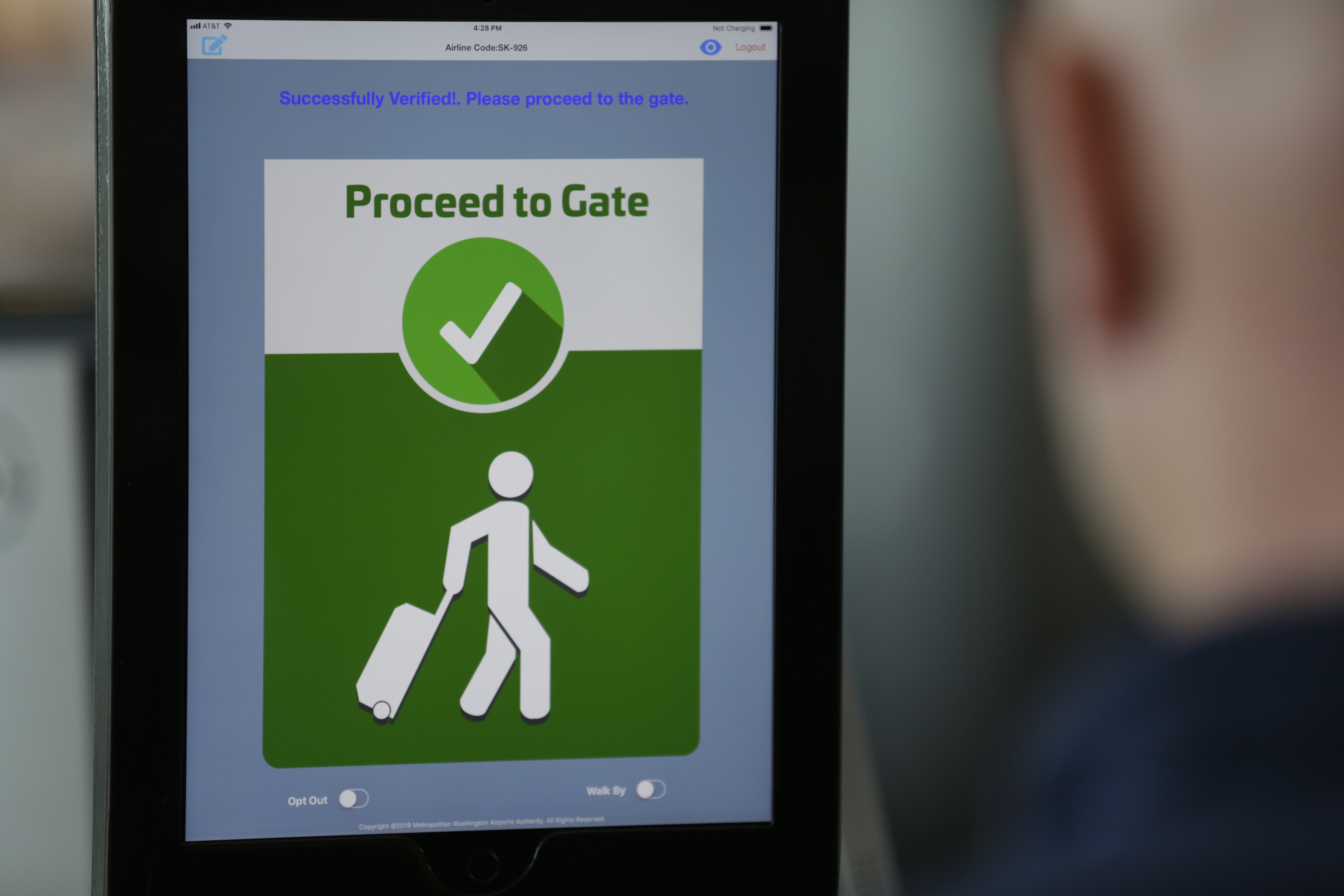 A facial recognition tablet tells a passenger to proceed to the gate. 