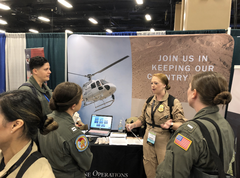 Air Interdiction Agent Presley Rose talks with military members at the 2022 Women in Aviation International Conference in Nashville, Tennessee, in March 2022.