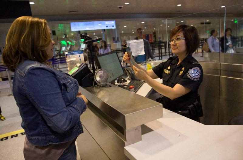 A CBP officer processes an international passenger at Boston Logan International Airport. Photo by Glenn Fawcett