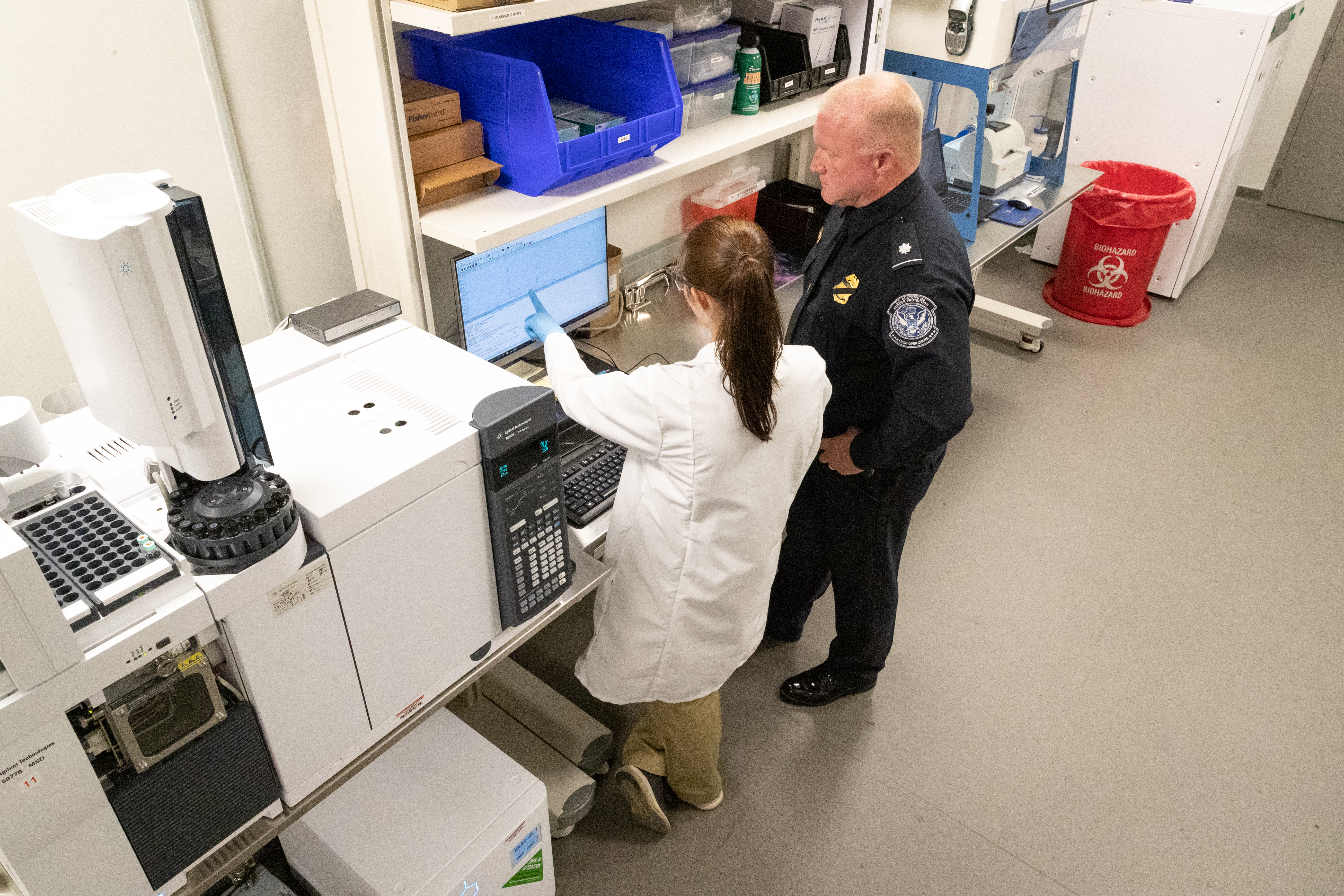CBP scientist and CBP officer work in a lab