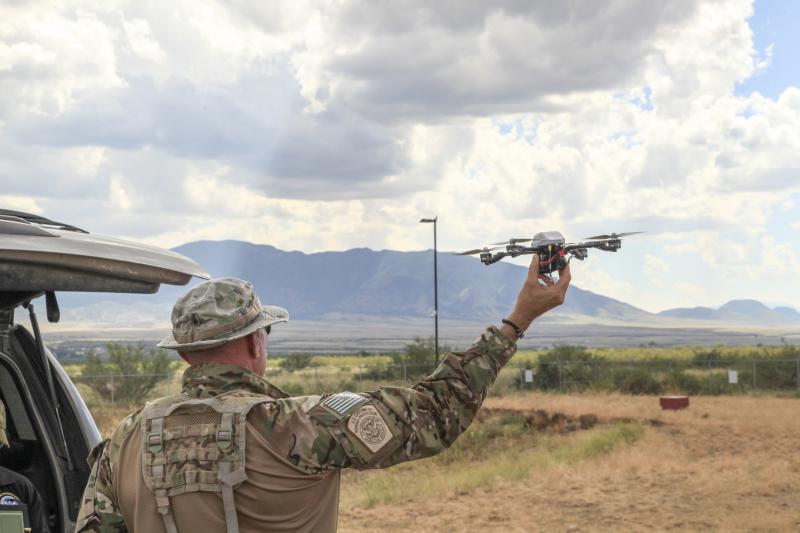 A Border Patrol agent launches a small, remote-controlled four-bladed helicopter being tested in the Arizona desert to help augment agents’ efforts, as well as new border wall improvements being made to the whole system. Photo by Carole M. Condon