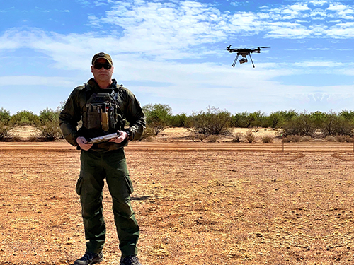 Border Patrol Agent Zach Pruett operates a small, unmanned aerial system – better known as a drone. The drones give agents an edge when tracking drug traffickers and migrants who crossed the border illegally. A U.S. Customs and Border Program called Cost-Wise Readiness helps make sure more of the drones are in operators’ hands. Photo by Border Patrol Agent Eric Edney. Graphic by Janice Swan-Jones