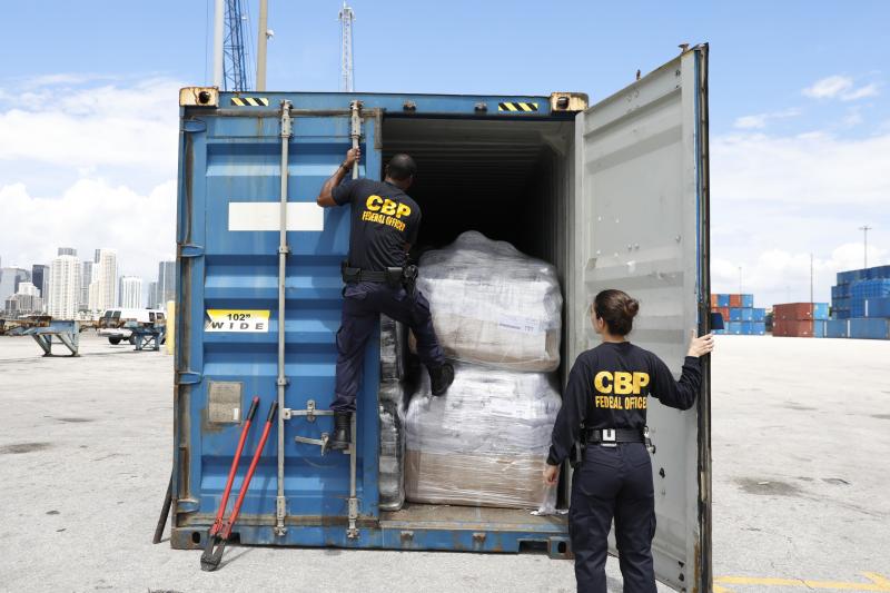 Photograph of Female and Male CBP Officers inspecting cargo at port of entry. Click photo for information on Office of Field Operations 