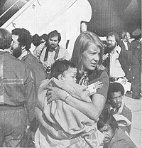 Denise Crawford of the U.S. Customs Service holds a Vietnamese refugee.
