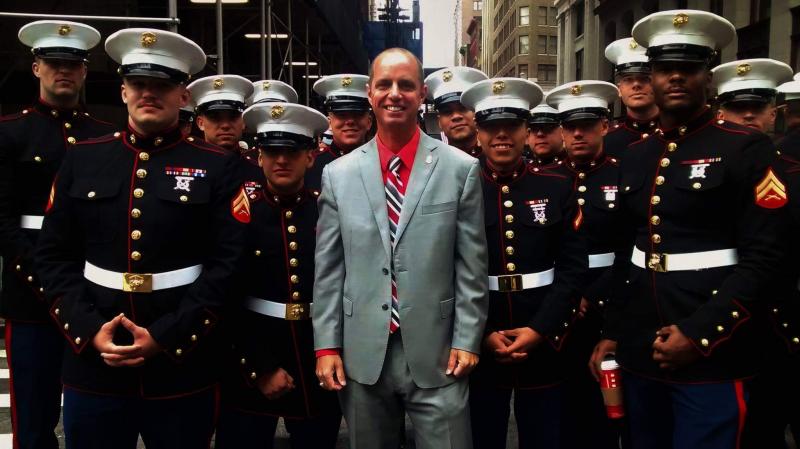 Jeffrey R. Jack, Veterans Employment Program Manager, U.S. Customs and Border Protection standing with a group of United States Marines in uniform at the Veteran's Day parade in New York City. 
