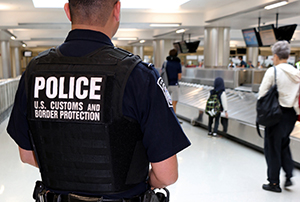 A CBP officer observes international airline passengers in this file image from Washington Dulles International Airport.