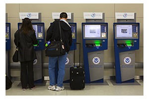 Travelers using Global Entry kiosks