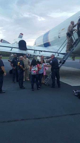 Evacuees depart an AMO P-3 aircraft upon arriving at Homestead Air Reserve Base. 