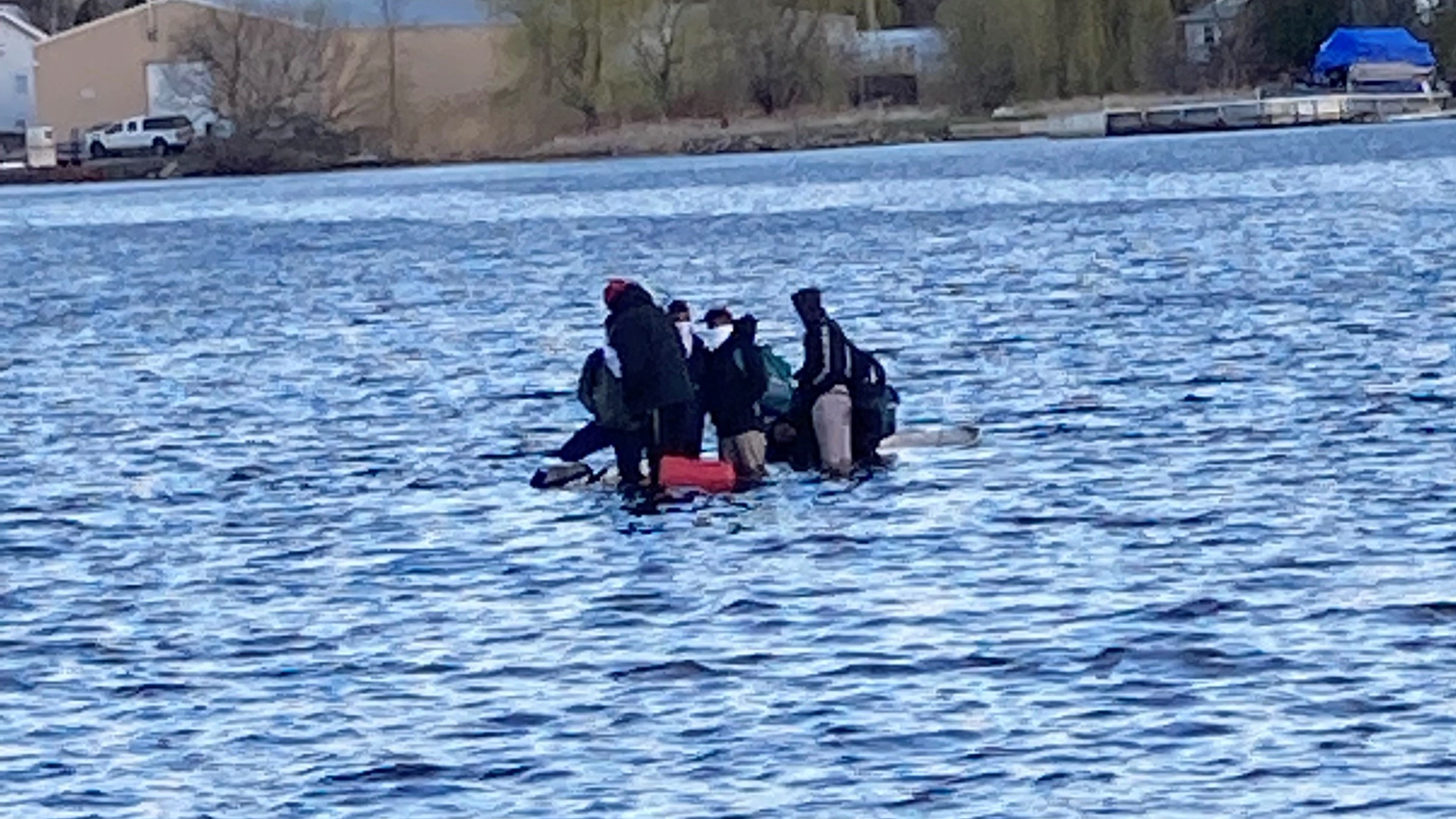 A close up of a boat with 7 people onboard, sinking. 