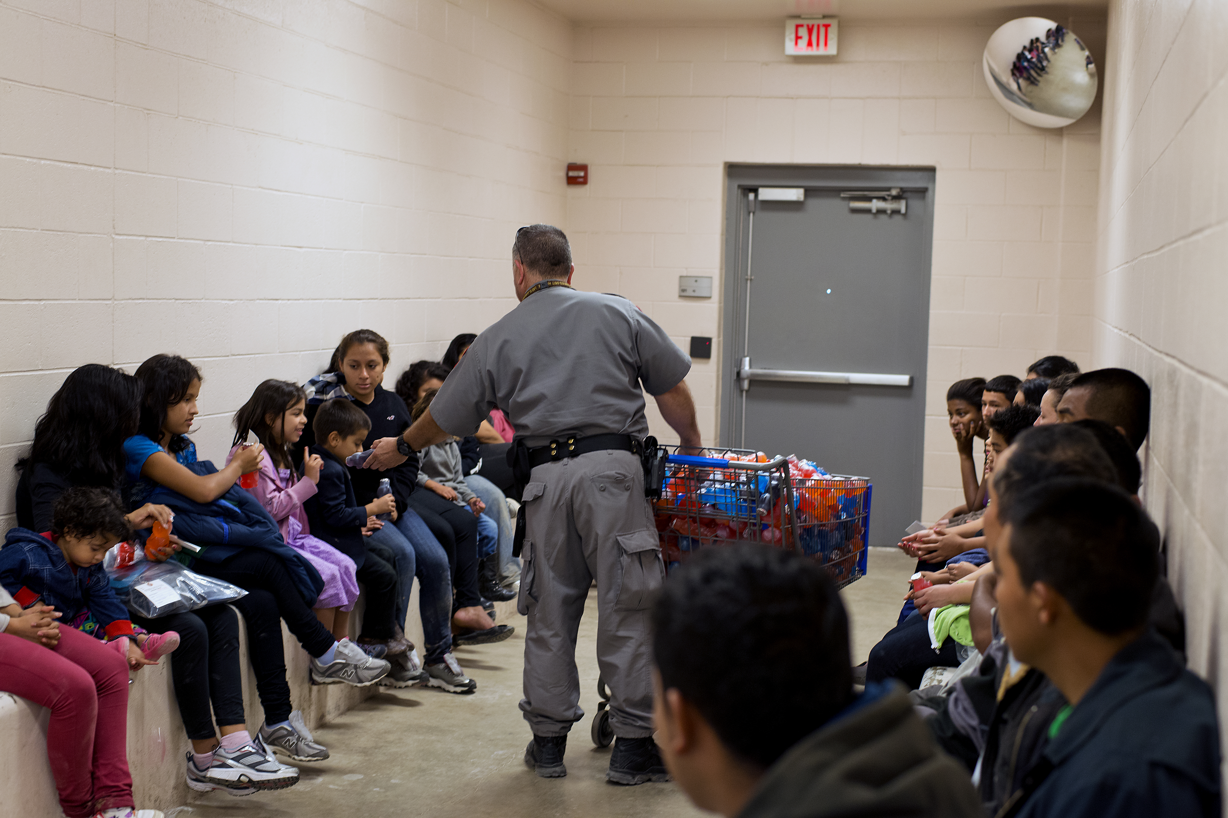 An officer distributes juice at McAllen, Texas Border Patrol facility. (Photo by Hector Silva)