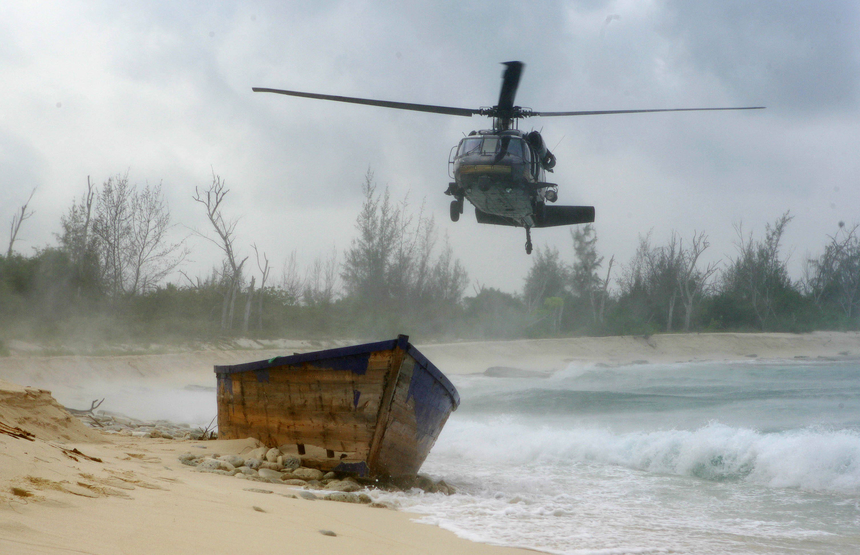A CBP UH-60 Blackhawk helicopter flies over an island in Puerto Rico searching for people seeking asylum in the US.
