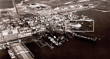 1934 aerial view of East Boston and Boston Harbor (with immigration station highlighted.) This view shows the second story of the station that was added after 1929 and the fenced rooftop recreation area for the use of the immigrants detained at the station, which was added sometime between 1925 and 1931.