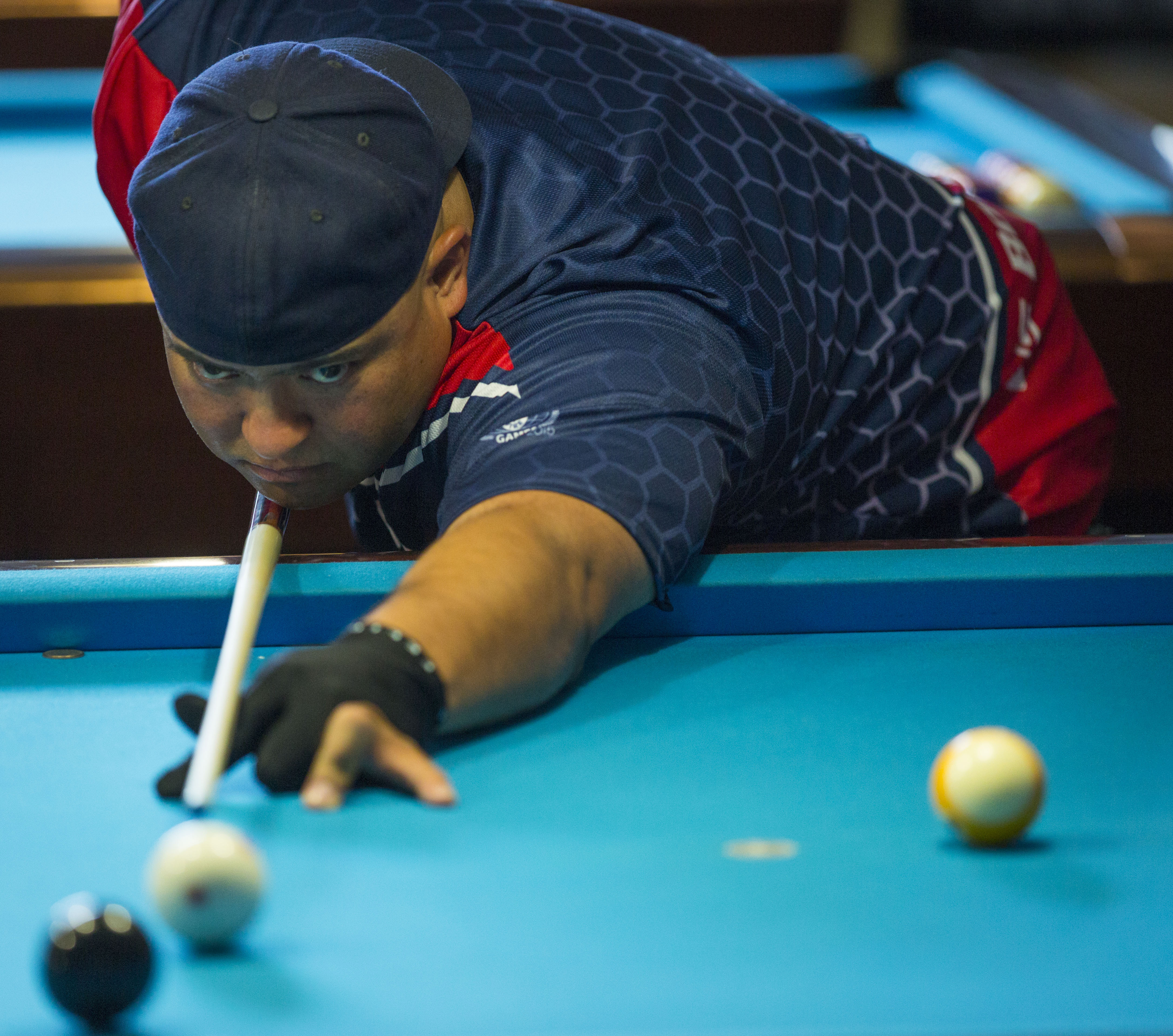 Sighting a winning shot, Border Patrol Agent James Garcia competes in the pocket billiards contest at the 2015 World Police & Fire Games. Photo by James Tourtellotte