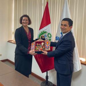 EAC AnnMarie R. Highsmith accepts a cultural token of appreciation from superintendent of National Superintendence of Customs and Tax Management Luis Enrique Vera Castillo.