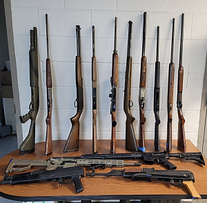 An assortment of weapons leaning against a wall and on a table seized by CBP officers at Eagle Pass Port of Entry during an outbound examination.