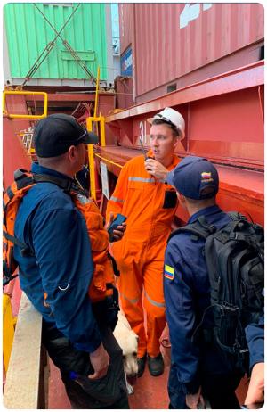 CSI Officer Daniel Castro on board a cargo vessel at the port of Cartagena, Colombia, speaking with a crewmember alongside members of the Colombian Armada.