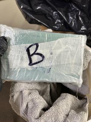 Photo of fentanyl seized held up on bucket with a towel inside