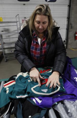 Helene Warren-Cutler inspects sports jerseys for counterfeit products.