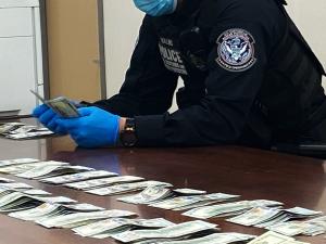 Customs and Border Protection officer counting cash on a table