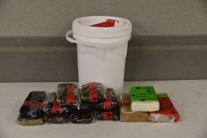 Packages and a bucket containing $1.1 million in cocaine, heroin and methamphetamine seized by CBP officers at Colombia-Solidarity Bridge.