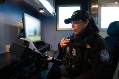 CBP officer speaks to another officer on her radio after reviewing X-ray images.