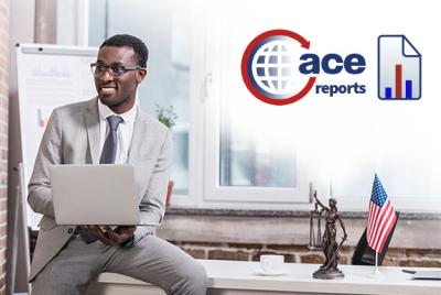 Smiling Black man with glasses holding laptop, sitting on edge of a desk, with small lady justice statue and small US flag, in front of a window and note board easel showing chart graphic with Ace reports logo in top right corner