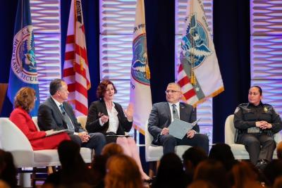 Office of Trade EAC AnnMarie Highsmith on stage providing remarks during the Leadership Town Hall at the TFCS in Boston. She is in the center, seated, with other CBP leaders around her.
