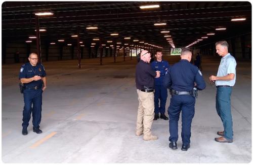 CBP Chief Medical Officer Dr. Tarantino, far right, and LCDR McMurray, back center, of CBP’s Office of the Chief Medical Officer brief leadership regarding public health and habitability requirements during the buildout of a temporary holding facility at Dulles International Airport in Dulles, Va., during Operation Allies Welcome, in August 2021.