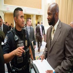 A CBP officer and a candidate talk at a career fair. 