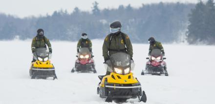 Photo of agents on snowmobiles on the St. Lawrence River.