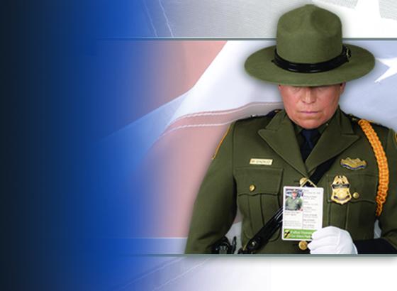 A Border Patrol agent holds the Silent Partner card of a fallen agent.